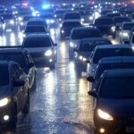 Engarrafamento no trânsito de Brasília sob chuva intensa, com acidentes causando caos viário.