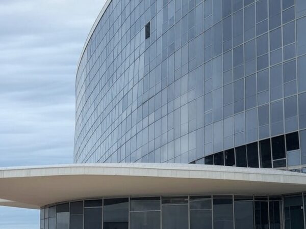 Edifício da CLDF em Brasília com símbolos de pedidos de impeachment e crise política no DF.