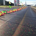Rua de Brasília decorada com bandeiras e confetes para o DF Folia 2026, representando blocos de carnaval.