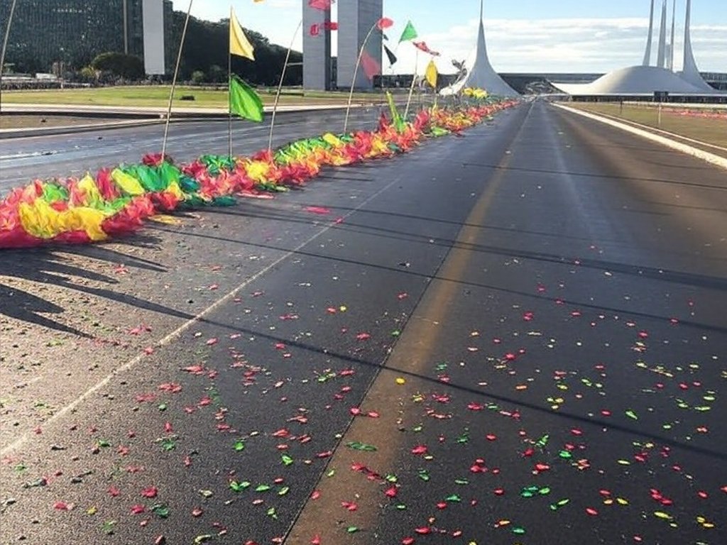 Rua de Brasília decorada com bandeiras e confetes para o DF Folia 2026, representando blocos de carnaval.