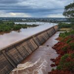 Reservatório do Descoberto transbordando no DF, expondo riscos de inundações e falhas no planejamento urbano.