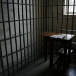 Cela de prisão brasileira com Bíblia e cruz, simbolizando assistência religiosa.