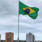 Cemitério europeu com bandeira brasileira sobre túmulo, representando sepultamento de voluntário Kauan Victor morto na Ucrânia.