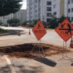 Vista da Asa Norte em Brasília com caminhão da Caesb e edifícios governamentais, representando suspensão de água afetando Senado e Presidência.