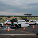 Cena de acidente com van tombada na BR-020 em Planaltina, com viaturas da polícia rodoviária federal ao fundo.