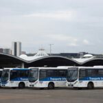 Frota de ônibus urbanos em garagem no DF, simbolizando capacitação de motoristas e cobradores para melhor atendimento.