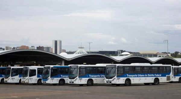 Frota de ônibus urbanos em garagem no DF, simbolizando capacitação de motoristas e cobradores para melhor atendimento.