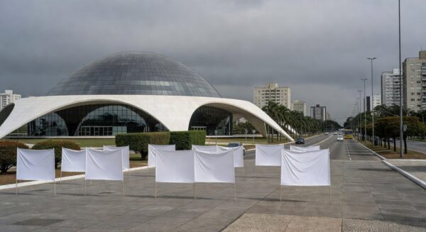 Edifício da CLDF em Brasília com elementos simbólicos de falhas no combate à violência.