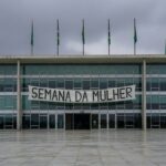 Edifício da CLDF em Brasília com banner da Semana da Mulher, criticado por evento superficial.