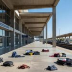 Rodoviária do Plano Piloto em Brasília com itens abandonados e viaturas policiais, sinalizando pânico causado por homem armado com faca.