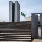 Edifício da CLDF em Brasília com bandeiras do Dia Mundial da Síndrome de Down, destacando críticas por falta de políticas efetivas.