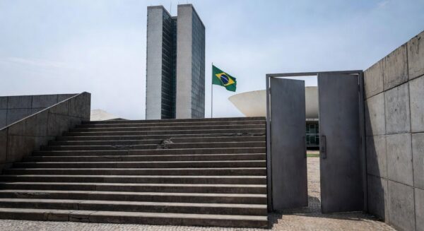 Edifício da CLDF em Brasília com bandeiras do Dia Mundial da Síndrome de Down, destacando críticas por falta de políticas efetivas.