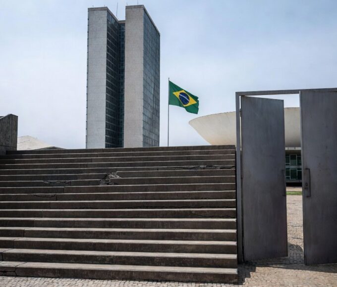 Edifício da CLDF em Brasília com bandeiras do Dia Mundial da Síndrome de Down, destacando críticas por falta de políticas efetivas.