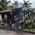 Casa residencial brasileira destruída por incêndio, representando condenação por assassinato em fogo.