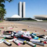 Cigarros eletrônicos descartados em calçada de Brasília, simbolizando uso entre estudantes de 13 a 17 anos.