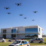 Drones voando sobre residência em Brasília com viaturas da PMDF ao redor.