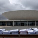Edifício da CLDF em Brasília com documentos financeiros, representando aprovação de reestruturação de carreira e críticas por gastos excessivos no DF.