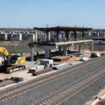 Obras de expansão da Linha 1 do Metrô-DF em Samambaia, com 23% de conclusão, mostrando trilhos e estruturas em construção.