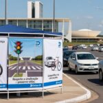 Ação educativa do Detran-DF em rua de Brasília, com estande e sinalizações de trânsito, promovendo segurança viária no Distrito Federal.
