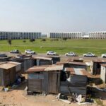 Área de favela na 913 Sul em Brasília durante desocupação pelo GDF, com barracos e veículos oficiais no Plano Piloto.