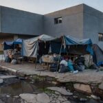 Rua em Brasília com abrigos improvisados representando situação de rua no DF