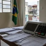 Urna eleitoral e documentos de manifesto em seção de votação no Brasil